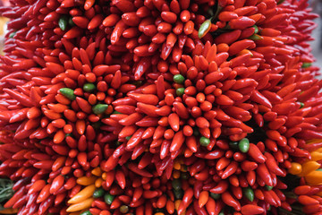 Red hot chilli peppers pattern texture background. Close up. A backdrop of raw food. Street vegetable market. Group of Red green and orange hot chilli peppers