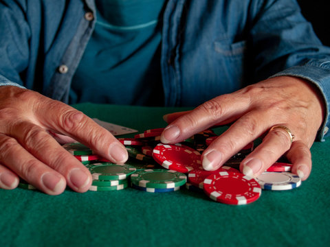 A person playing poker betting poker chips of various colors