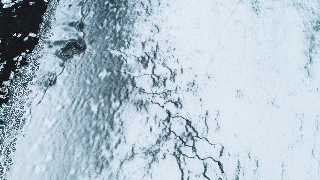 A frozen body of water breaking into pieces