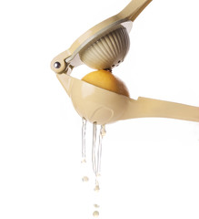 Esprimidor de cítricos esprimiendo un limón en primer plano sobre un fondo blanco
