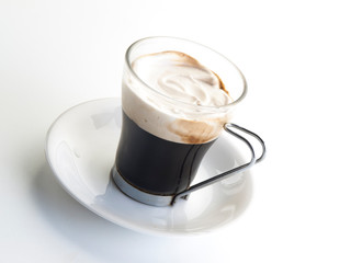 Taza de cristal con café capuchino en su interior visto cenitalmente