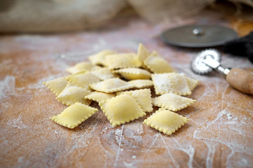 Fototapeta na wymiar Preparing fresh natural ravioli on wooden kitchen table, traditional Italian pasta