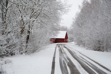 Red cottage at the end of the road in Scandinavia winter landscape
