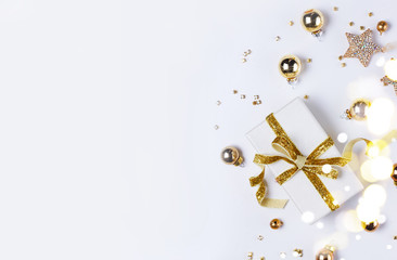 Fototapeta premium Świąteczna płaska scena świecka z pudełkiem git ze złotym węzłem łukowym i złotymi dekoracjami