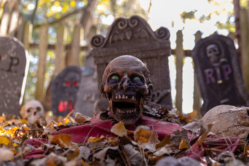 Obraz premium Decorated cemetery with tombstones, zombies and skeletal remains. Halloween theme