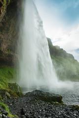 Famous waterfall Seljalandsfoss in Iceland, adventure outdoor travel Icelandic summer background
