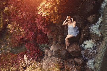 Beautiful woman in fairy forest near a stream. Girl model in the forest, among the grass and leaves...