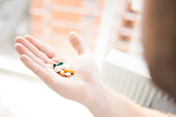 Tablet and capsule in man's hands. Over weight fat man holding drugs or medicine in his hand. illness concept