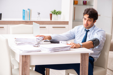 Man under stress measuring his blood pressure