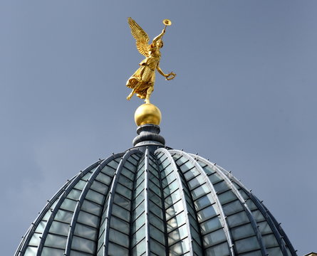 Goldene Fama-Figur auf der gefalteten Glaskuppe ("Zitronenpresse") der Kunstakademie vor blauem Himmel