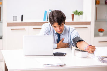 Man under stress measuring his blood pressure