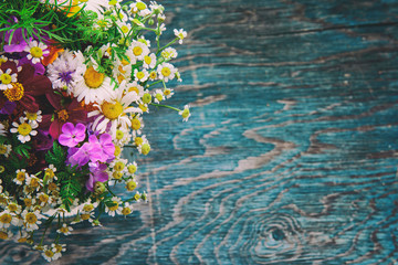 Bouquet of fresh summer flowers on the blue wooden grunge desk. Design for easter greeting cards, holiday postcards, invintation in vintage hipster eco rustic style with copy space