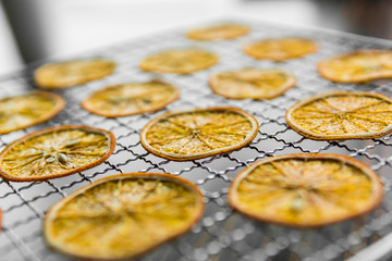 Candied orange slices on grid for drying. Dried fruits which can be used as a decoration to the meal or cocktails. Healthy vegetarian food rich on a vitamins and microelements.