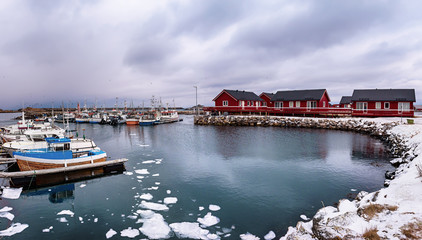 Fototapeta na wymiar Scenic view of beautiful winter sea coast with fisherman boats and red rorbu houses at Lofoten Islands in Northern Norway