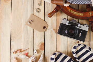 Fototapeta na wymiar Camera, espadrilles and maritime decorations on the wooden background