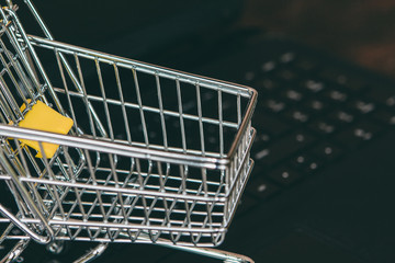 Small trolley on a computer keyboard. Shopping sales concept.