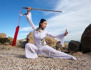 Young woman dancer with a sword on a Connecticut beach.