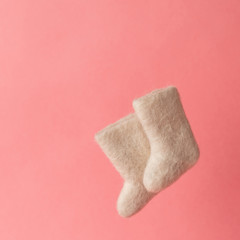 woolen warm winter shoes valenki on a pink background. the concept of winter. winter shoes