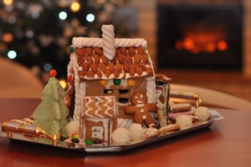 Fototapeta na wymiar Homemade gingerbread house, man, Christmas tree and fireplace