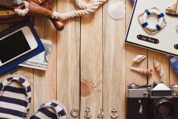 Striped espadrilles, camera and maritime decorations on the wooden background
