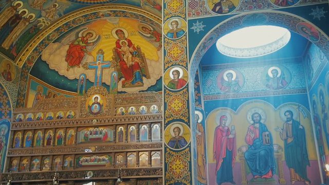 Interior of the Orthodox Church, altar, iconostasis, and beautiful historic architectural arches, 
painted icons, frescoes, bas-reliefs in natural light.