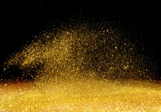 Golden powder scattered over the dark background