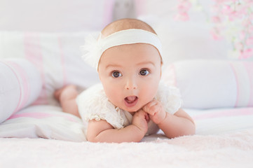 Portrait of a crawling baby on a bed in his room. The concept of a happy child. Diapers.