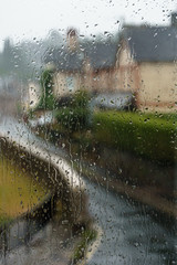 inside view of a wet window on a very rainy day, outside is a cold wet street - symbol for bad mood, aloneness, frustration, bad day
