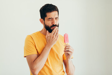 Man have sensitive teeth with ice on white background