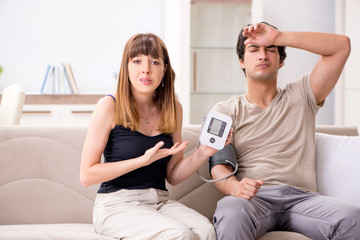 Wife checking husband's blood pressure 