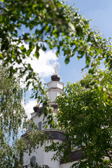 The modern architecture of Catholic Church with big green trees and beautiful cloudy sky