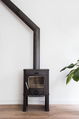 iron fireplace like a stove in a house with fire, scandinavian interior modern design, white room