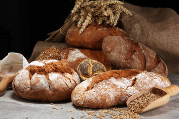 Different kinds of bread and bread rolls on board from above. Kitchen or bakery