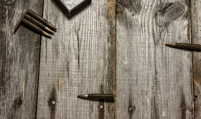 Disassembled clip with cartridges 7,92 x 57 - rustic ammos lies on the wooden background