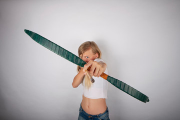 Young archer girl targeting on you with bow and arrow