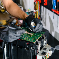 Close up. Men Repairing Hardware Equipment in Workshop. Repair Shop