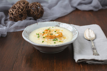 Creamy Cauliflower Soup topped with Brown Butter and Chives in a Rustic Setting