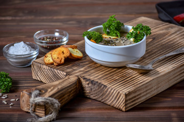Mushroom cream soup on wooden background, selective focus