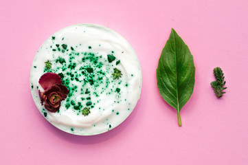 Natural cosmetics and leaves on pink background. Personal care with natural ingredients. Composition of cosmetics close-up.  Flat lay.