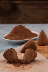 Chocolate candies in cocoa powder for dipping on confectionery paper.