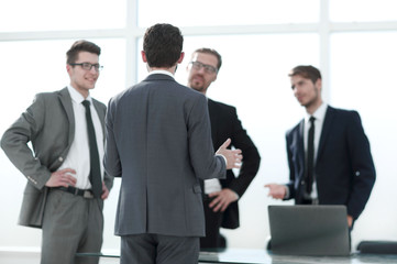 boss talking to employees standing in the office