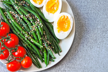 A plate with a healthy meal. Green beans, boiled eggs, cherry tomatoes. Keto diet. Keto snack.