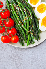 A plate with a healthy meal. Green beans, boiled eggs, cherry tomatoes. Keto diet. Keto snack.