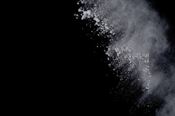 White powder explosion on black background. Dust splatted isolated. Paint Holi.