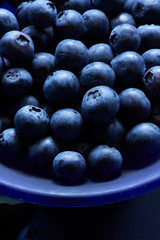 A purple bowl full of blueberries. 