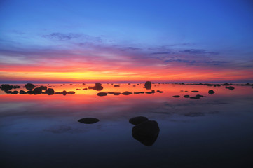 Dark orange last light at sunset over a still sea