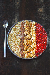 Healthy breakfast. Vegan breakfast bowl. Oatmeal, nuts, peanuts, flaxseeds, pomegranate seeds.