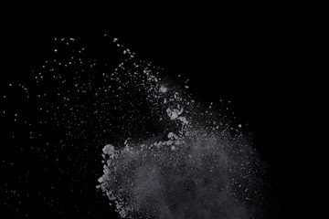 Obraz premium White powder explosion on black background. Dust splatted isolated. Paint Holi.