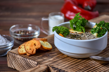 Mushroom cream soup on wooden background, selective focus