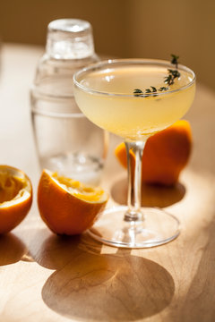 Cocktail in stemmed glass with meyer lemons and thyme
